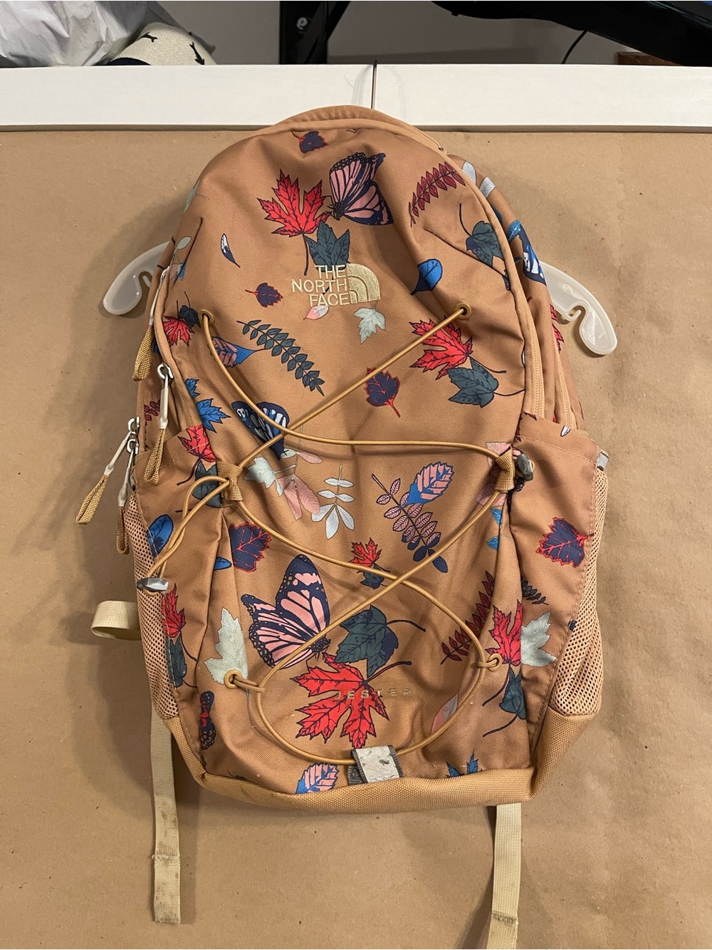 The North Face tan floral & butterfly backpack